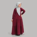 Side view of maroon tiered frill abaya for girls showing graduated frock tiers and long button-cuff sleeves